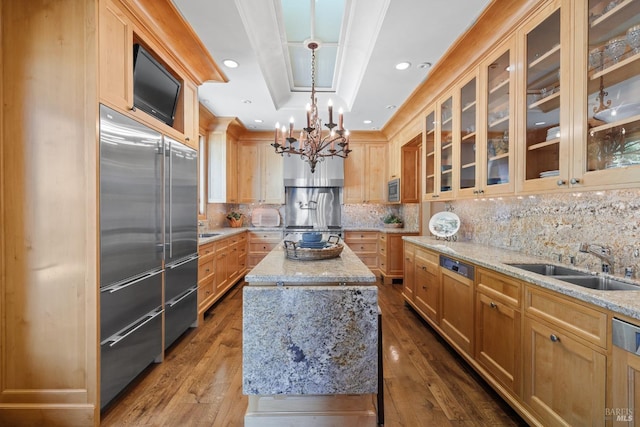kitchen with a center island, a sink, a chandelier, stainless steel appliances, and dark wood-style floors