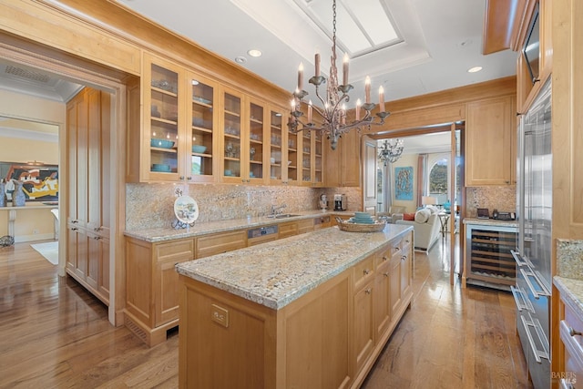 kitchen with a chandelier, tasteful backsplash, a center island, and a sink