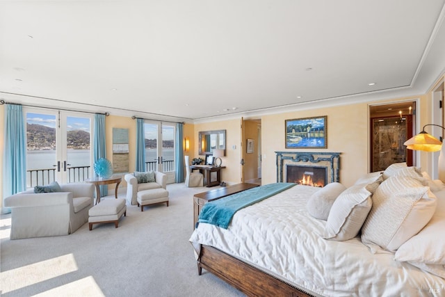 bedroom featuring crown molding, light carpet, a fireplace, and access to exterior