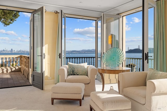 sitting room featuring carpet and a water view