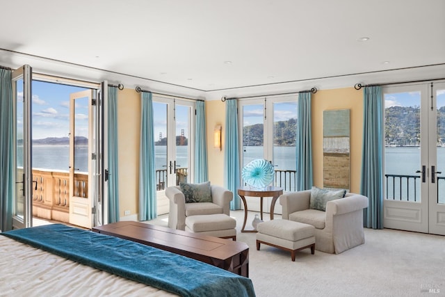 bedroom featuring french doors, a water view, and access to exterior