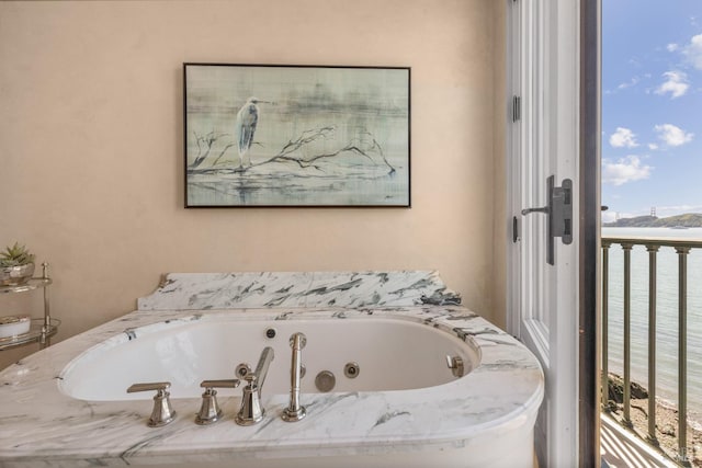bathroom with a wealth of natural light and a tub with jets