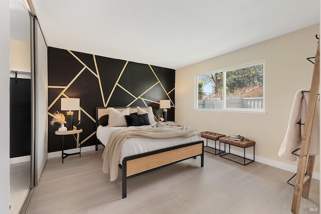 bedroom featuring light wood-type flooring and baseboards