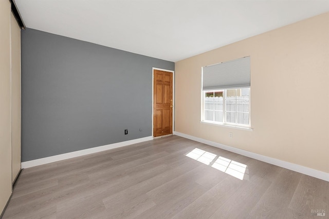unfurnished room featuring wood finished floors and baseboards