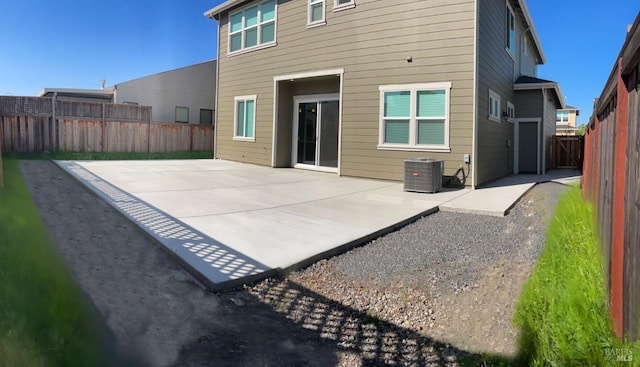 rear view of property featuring a patio, a fenced backyard, and central AC