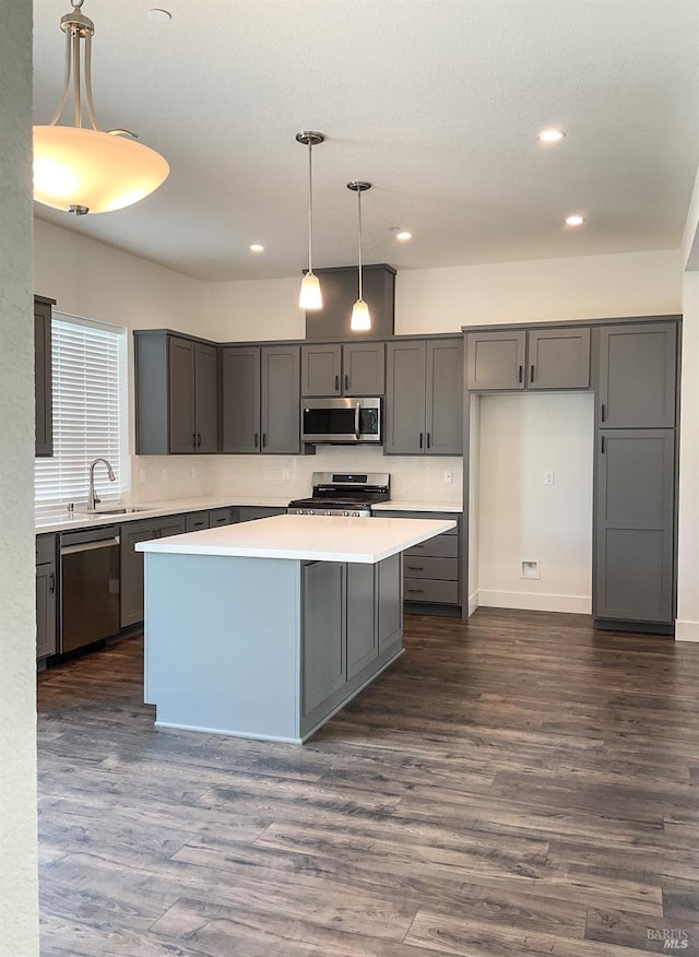 kitchen featuring recessed lighting, gray cabinetry, a kitchen island, and stainless steel appliances