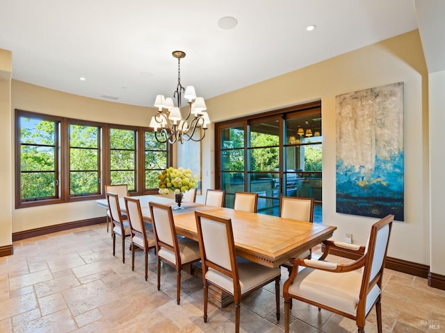 dining room with baseboards, a chandelier, and stone tile floors