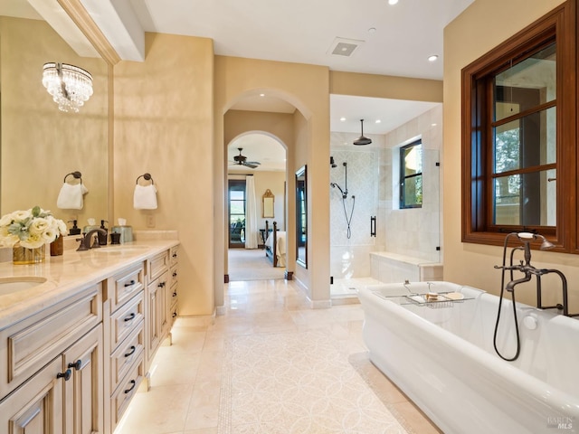 bathroom with a sink, double vanity, a soaking tub, recessed lighting, and a tile shower