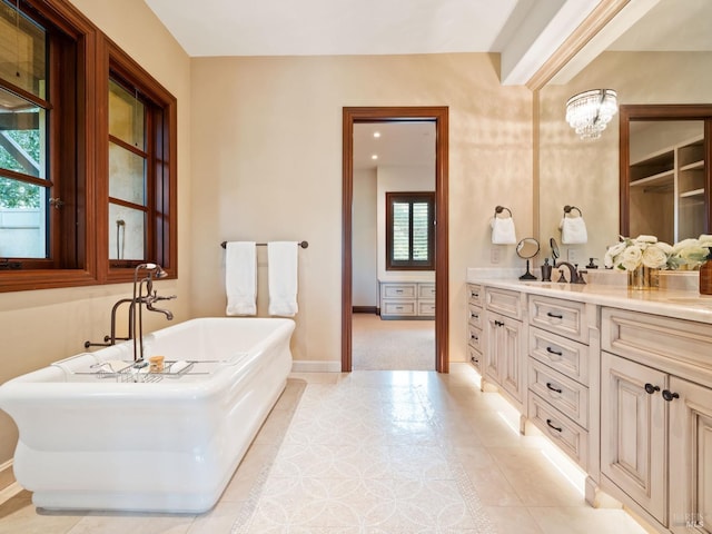 full bathroom with baseboards, a freestanding tub, a chandelier, vanity, and tile patterned floors