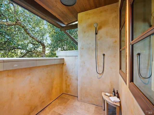 bathroom featuring wood ceiling and stone finish floor
