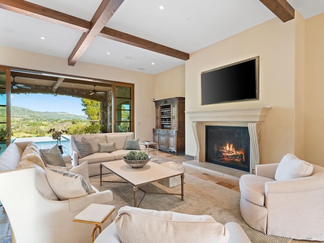 living room with a ceiling fan, beamed ceiling, a glass covered fireplace, and recessed lighting