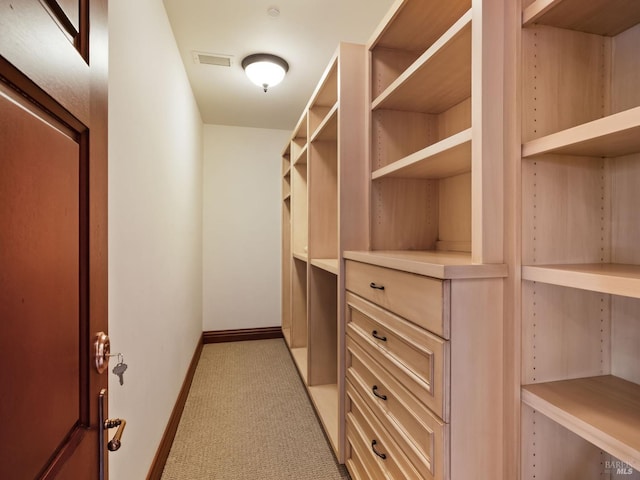 spacious closet with visible vents and light colored carpet