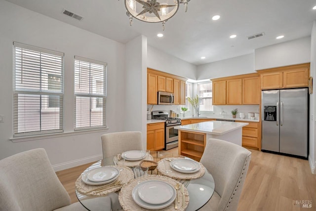 kitchen featuring stainless steel appliances, light wood finished floors, visible vents, and light countertops