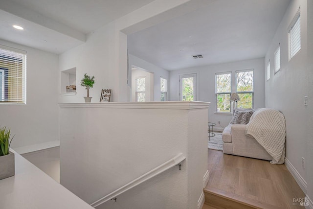 staircase with wood finished floors, baseboards, visible vents, and recessed lighting