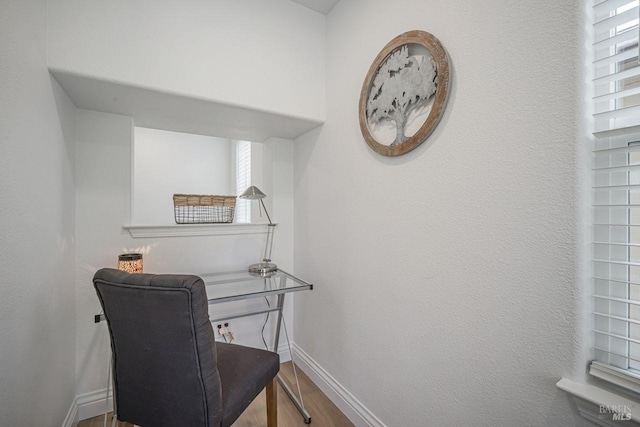 office space with wood finished floors, baseboards, and plenty of natural light