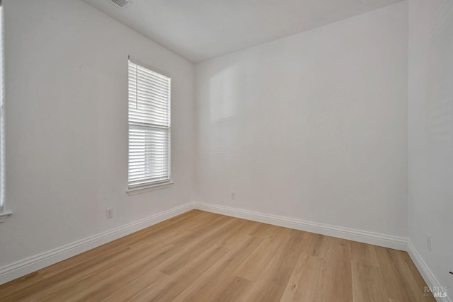 unfurnished room with light wood-style floors, baseboards, and visible vents