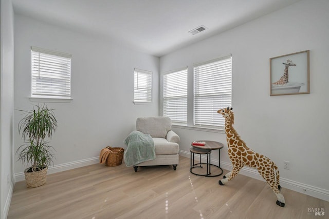 sitting room featuring wood finished floors, baseboards, and visible vents
