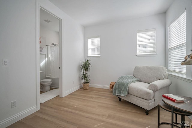 sitting room with plenty of natural light, light wood-style flooring, and baseboards