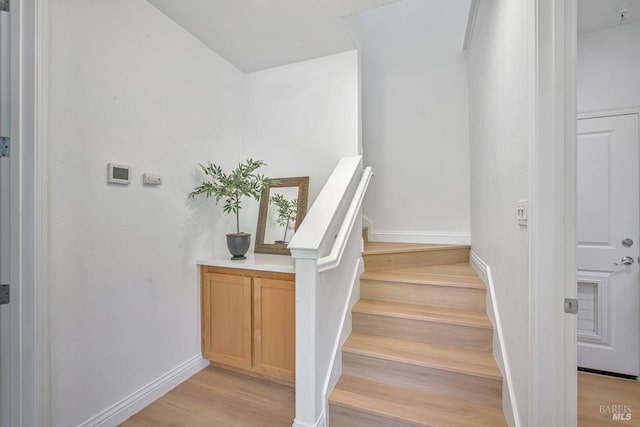 stairs with baseboards and wood finished floors