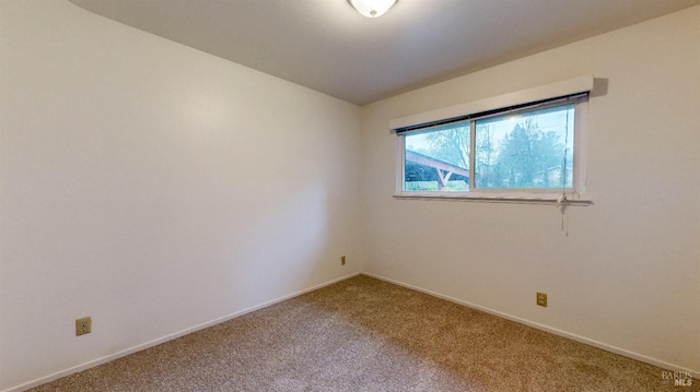 carpeted spare room with baseboards