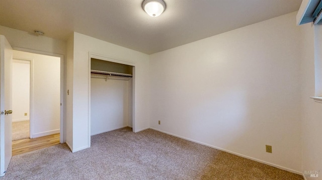 unfurnished bedroom featuring a closet, baseboards, and carpet