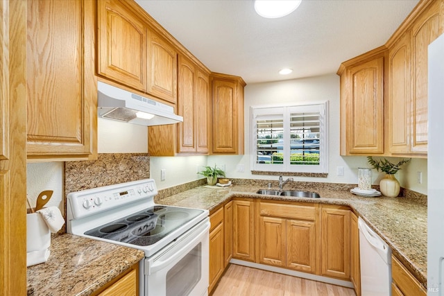 1811 Pacifica Ct, Benicia, CA 94510 - kitchen featuring white appliances, light wood-style flooring, light stone countertops, under cabinet range hood, and a sink