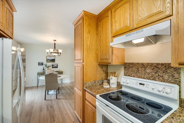 1811 Pacifica Ct, Benicia, CA 94510 - kitchen with a notable chandelier, white appliances, under cabinet range hood, brown cabinetry, and light wood finished floors