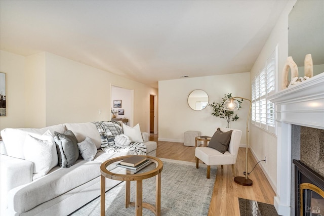 1811 Pacifica Ct, Benicia, CA 94510 - living room with a tiled fireplace, light wood-style flooring, and baseboards