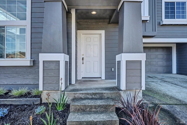 entrance to property featuring driveway and an attached garage