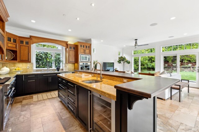 kitchen featuring beverage cooler, stainless steel appliances, a ceiling fan, a sink, and tasteful backsplash
