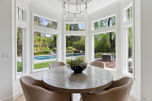 sunroom / solarium with baseboards, a high ceiling, a wealth of natural light, and crown molding