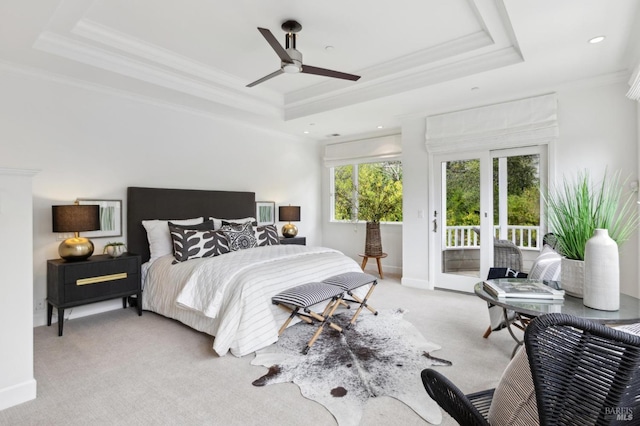 carpeted bedroom with a tray ceiling, access to exterior, french doors, crown molding, and ceiling fan