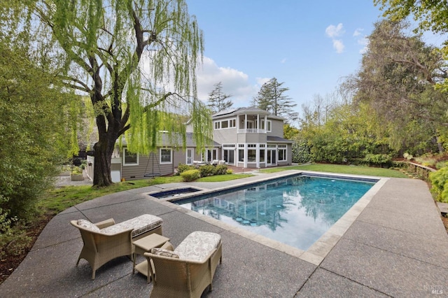 outdoor pool featuring a sunroom and a patio