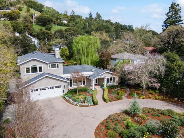 traditional home featuring a garage, driveway, and a chimney