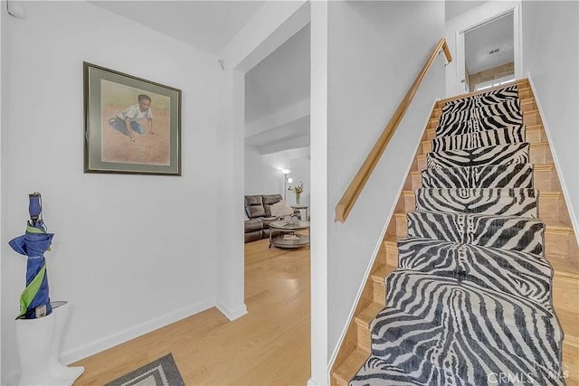 hall with light wood-style flooring and baseboards