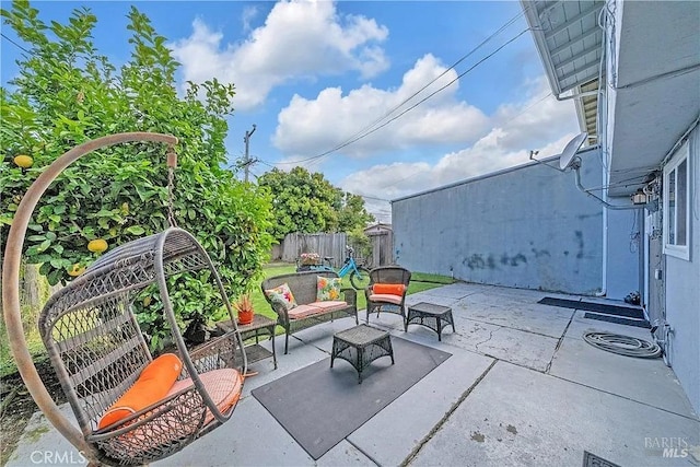 view of patio featuring outdoor lounge area and fence
