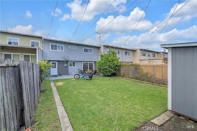 back of property featuring a yard, a fenced backyard, and stucco siding