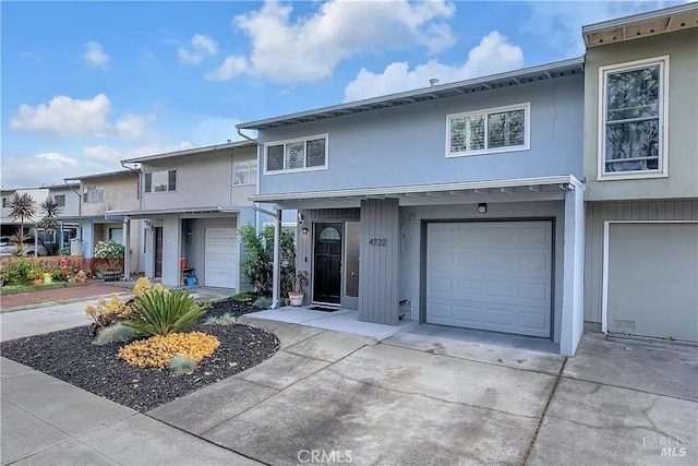 view of property with an attached garage and concrete driveway