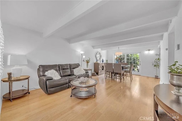 living area with beamed ceiling and wood finished floors