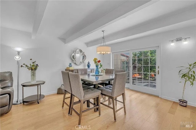 dining room featuring baseboards, light wood-type flooring, and beamed ceiling