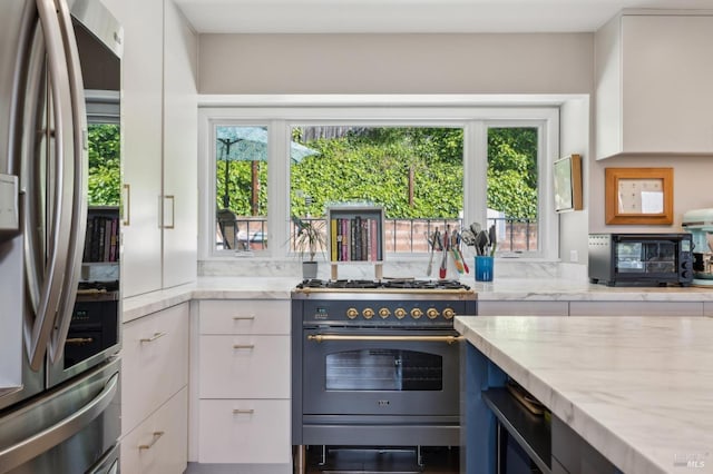 299 Via Barranca, Greenbrae, CA 94904 - kitchen featuring stainless steel appliances, plenty of natural light, white cabinetry, and light stone counters