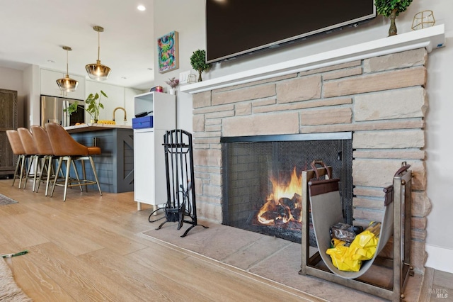 299 Via Barranca, Greenbrae, CA 94904 - details featuring wood finished floors, stainless steel fridge with ice dispenser, a stone fireplace, and recessed lighting