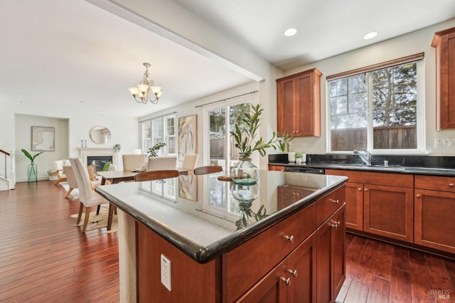 kitchen featuring an inviting chandelier, recessed lighting, a sink, open floor plan, and dark wood-style floors