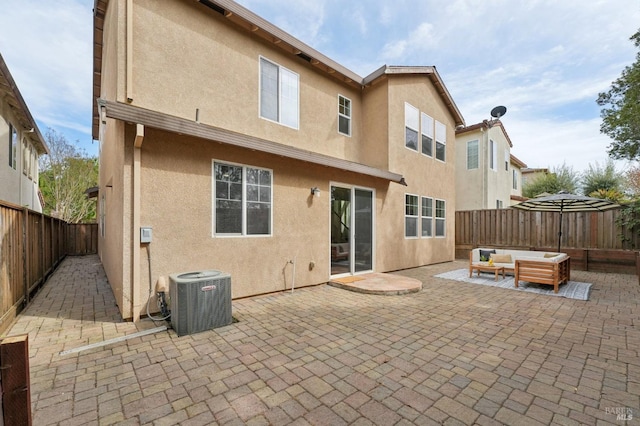 back of property featuring cooling unit, an outdoor hangout area, stucco siding, and a fenced backyard