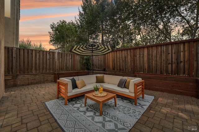 patio terrace at dusk with a fenced backyard and an outdoor living space