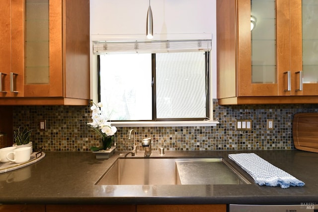 kitchen featuring brown cabinets, decorative backsplash, and glass insert cabinets