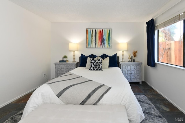 bedroom featuring baseboards and stone tile flooring