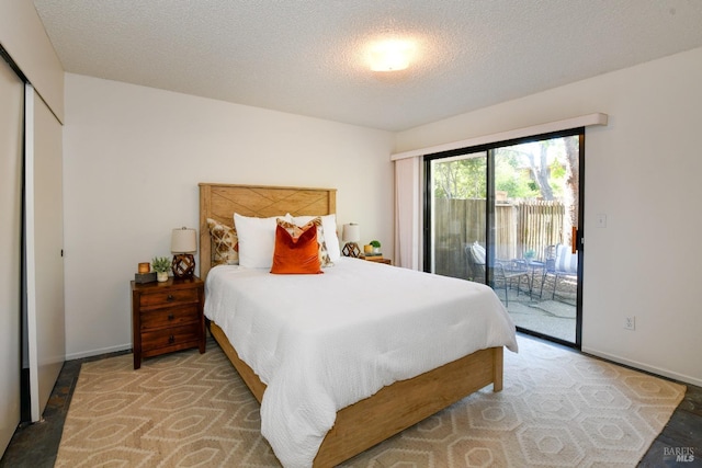bedroom with baseboards, access to exterior, and a textured ceiling