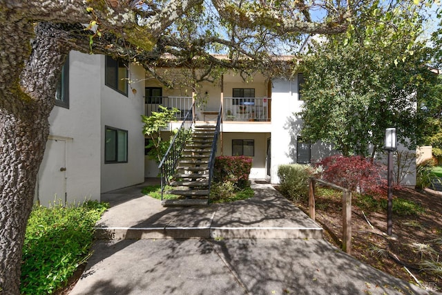 view of front of house with stairway and stucco siding