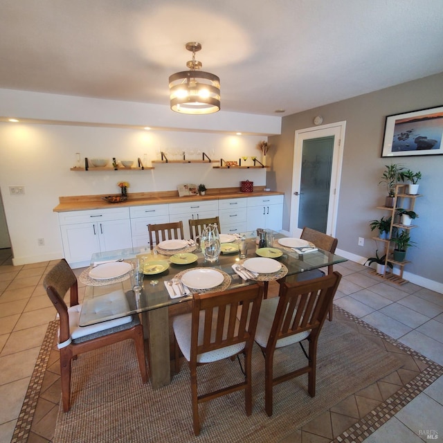 dining space featuring baseboards and light tile patterned floors
